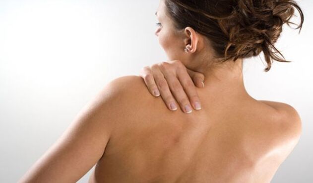 Η γυναίκα ανησυχεί για τον πόνο κάτω από την αριστερή ωμοπλάτη στην πλάτη από πίσω